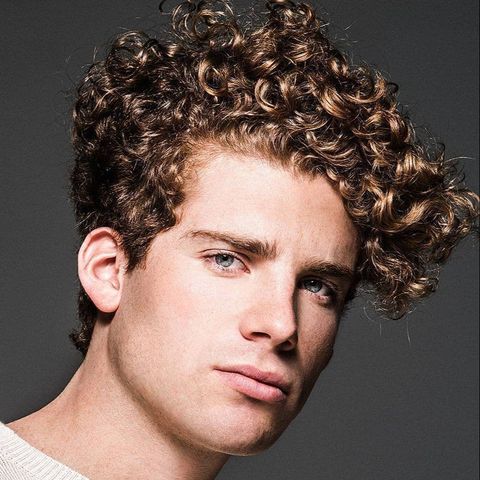 Curly short haircut with long fringe for men in 2021-2022