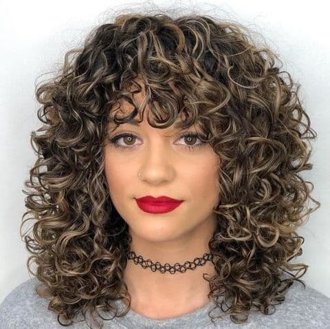 Highlights curly hairstyle with bangs for women in 2021-2022