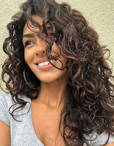 Long curly hairstyle with bangs for women in 2021-2022