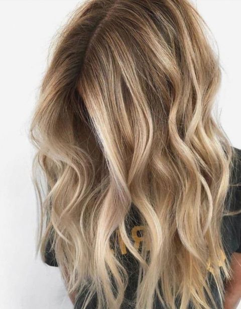 Center parted wavy hair with blonde balayage