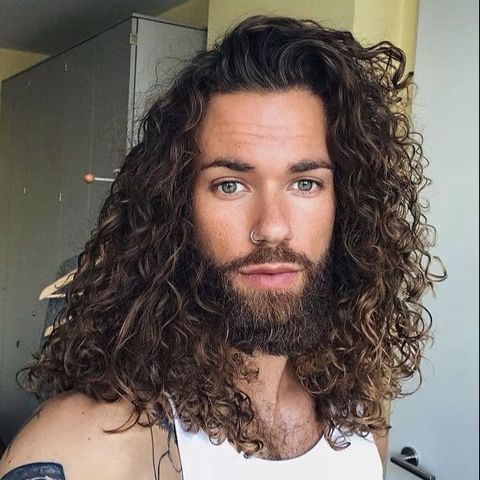 Side swept curly long hair for men with beard